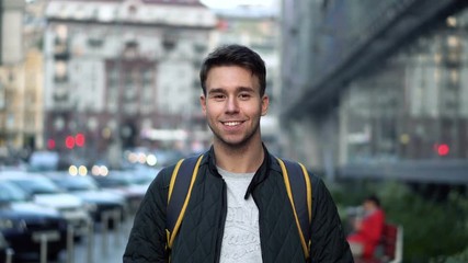 Portrait of Young happy smiling man standing in the street