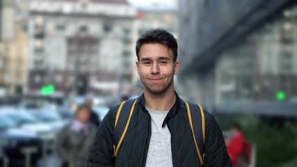Portrait of Young happy smiling man standing in the street