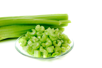 Cut and whole celery isolated on white background. Top view of vegetables. Concept of eating vegetables, using vegetables for dishes. Dish for a vegetarian. Healthy nutrition, vitamins.
