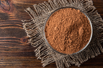 Cocoa powder on dark wooden background