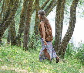 attractive hippie girl walking on a forest path