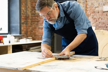 Mature handsome joiner work in carpentry. He is successful entrepreneur at his workplace.
