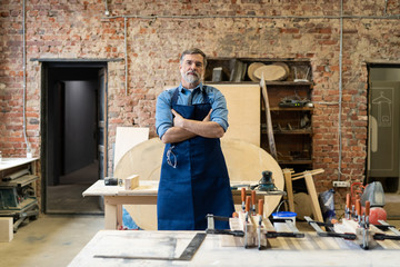 Mature handsome joiner work in carpentry. He is successful entrepreneur at his workplace.