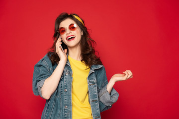 Cheerful young girl talking by mobile phone