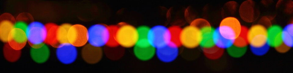 A long wide blurred garland of colored lights - the texture for the background