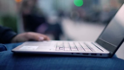 Close-up View of Man Using Laptop in the city street with bokeh effect