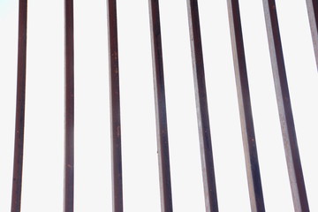 Silhouette of vertical bars of metal grating against white background - geometric lines texture for...