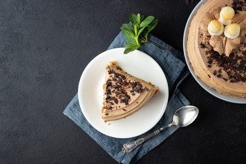 Tasty cake decorated with cream and dark chocolate on black background. Top view with copy space.