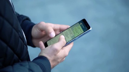 Close-up View of Man Using Smartphone in the city street