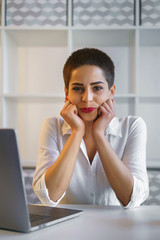 Young businesswoman sit on table in modern office