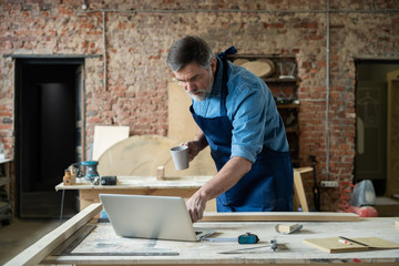 Mature handsome joiner work in carpentry. He is successful entrepreneur at his workplace.