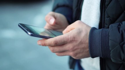 Close-up View of Man Using Smartphone in the city street