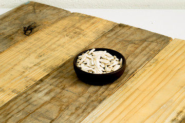 Sunflower seed in brown plate on wooden background