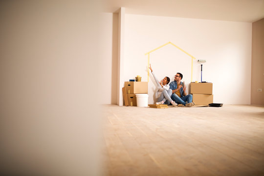 Happy couple decorating apartment.