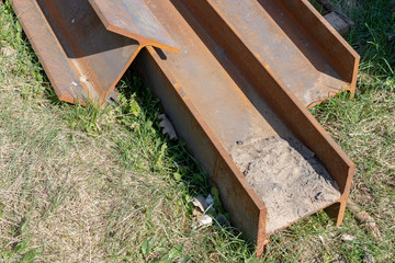 Large steel I-sections on the construction site. Poorly stored building materials.