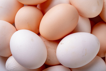 Fresh chicken eggs stacked on top of each other. A pile of eggs on the kitchen table.
