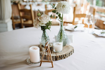 Wedding decorated table. Classy creative decor with flowers, candles and crystal name plate of table