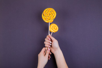 Two lollypops on a stick in hand.