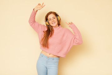 Beauty shoot of young fresh, full of energy girl with ginger hair listening to music.