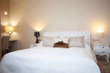 Luxury design interior of hotel room in soft brown and beige color tone. Peace and quiet. Sweet home. King size bed in the middle of the room. Blurred. Abstract. Unfocused.