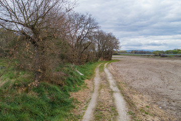 Fototapeta na wymiar Camino de tierra al lado de un campo arado en Ourense. Galicia, España.