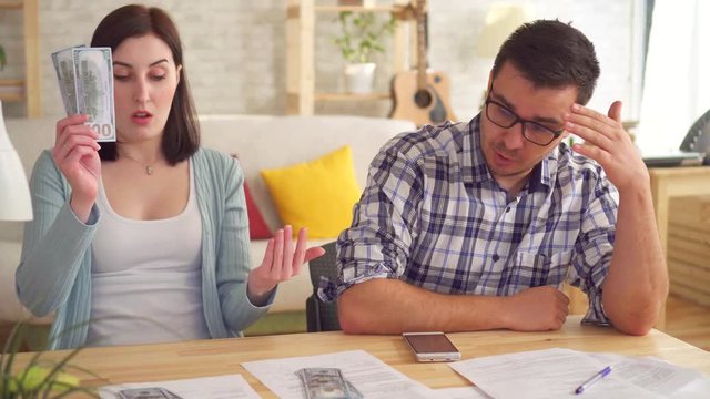 Close up young couple concerned and tense, doing the calculations documents with calculator