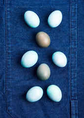 Easter boiled eggs as bunny symbol on blue jeans apron background. Holiday flat lay