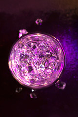 Glass of pure water with ice cubes. View from above. Abstract dynamic backdrop for your design