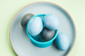Blue easter eggs on pastel green background. Festive symbol stille life