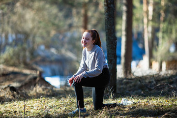 Cute teen girl is fooling around in a pine Park.