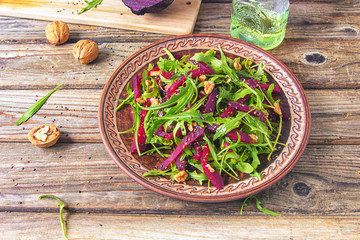 Spring detox salad salad with arugula and boiled beets with walnut kernel and roasted sesame seeds,...
