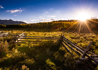 Dallas Divide in Colorado with western ranch style wooden fence in the foreground juxtaposed...