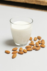 Almond milk and nuts. Organic vegan non-dairy plant-based milk in a glass.