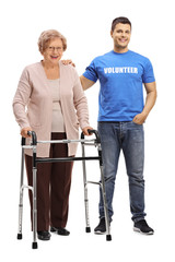 Young man volunteer and a senior woman with a walker
