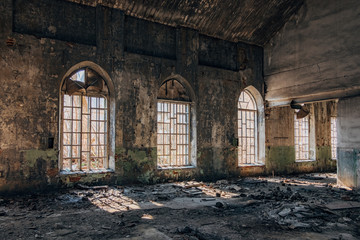 Old abandoned building with broken lancet windows inside 