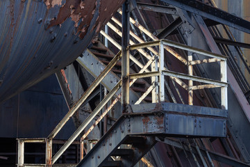 Bolted metal industrial stairway, peeled paint and rusted metal, horizontal aspect