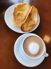 Brazilian breakfast. Bread toast with butter and coffee on a table.