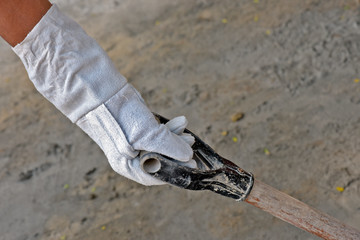 Mason holding a shovel, with protective gloves, PPE