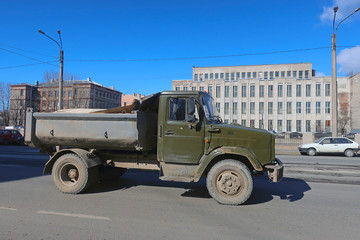 truck driving down the street on a sunny day