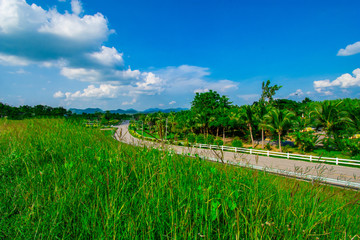 Obraz premium street view with green mountain on blue sky background in the province of Thailand. decoration image contain certain grain noise and soft focus.