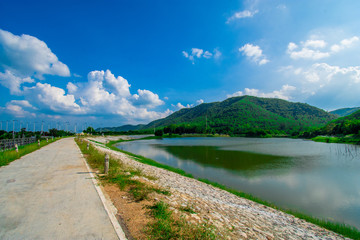 street view with green mountain on blue sky background in the province of Thailand. decoration image contain certain grain noise and soft focus.