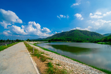 street view with green mountain on blue sky background in the province of Thailand. decoration image contain certain grain noise and soft focus.