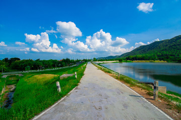 Fototapeta premium street view with green mountain on blue sky background in the province of Thailand. decoration image contain certain grain noise and soft focus.