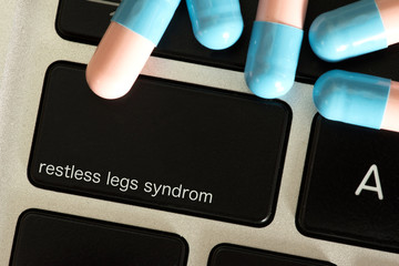 Tabletten und Computer mit einer Taste für Restless Legs Syndrom