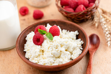 Ricotta, tvorog or cottage cheese with berries on a wooden table. Rustic food still life. Rich in Calcium and Protein healthy dairy product