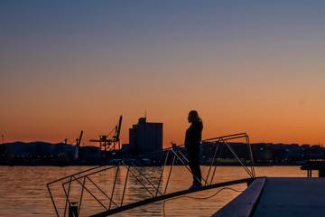 Stockholm, Sweden  A woman admires the sunset over the harbour.