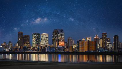 Osaka city view in Kansai, Japan at night with starry sky. Panoramic city background © SasinParaksa