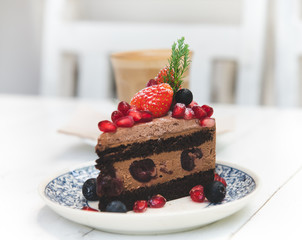 Chocolate cake topping with strawberry and berry fruits.