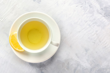 A photo of a cup of green tea with lemon, shot from above with a place for text