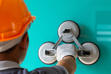 The glass technician is installing the glass with suction cups for installation.